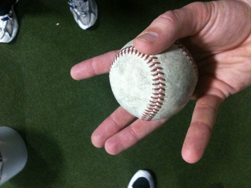 changeup grip - a hand holding a baseball
